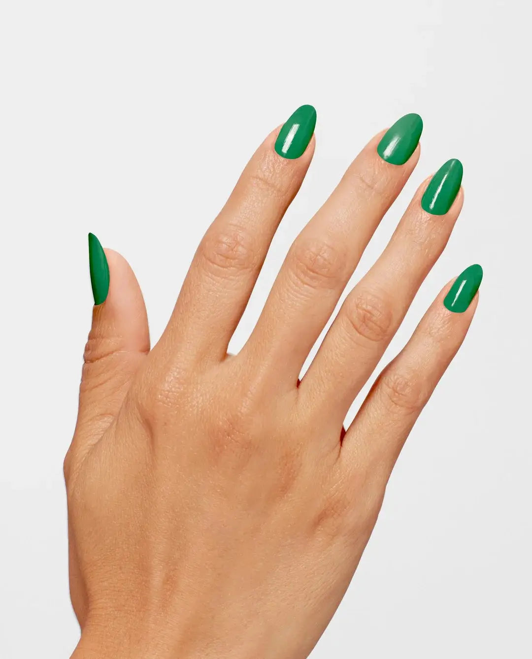 Hand with green nail polish on a light gray background