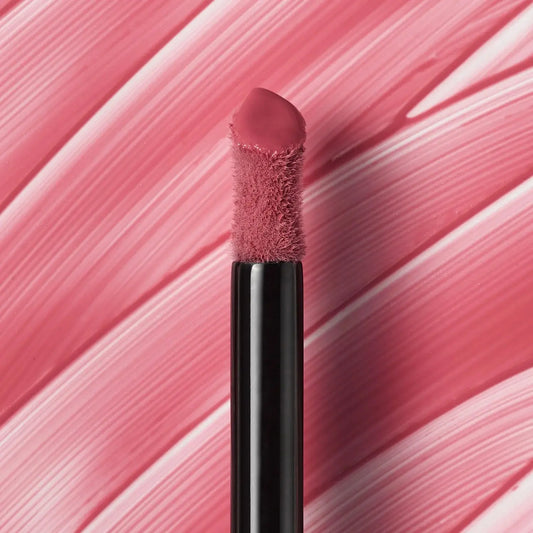 Lip brush with pink bristle tip on a pink and white striped background