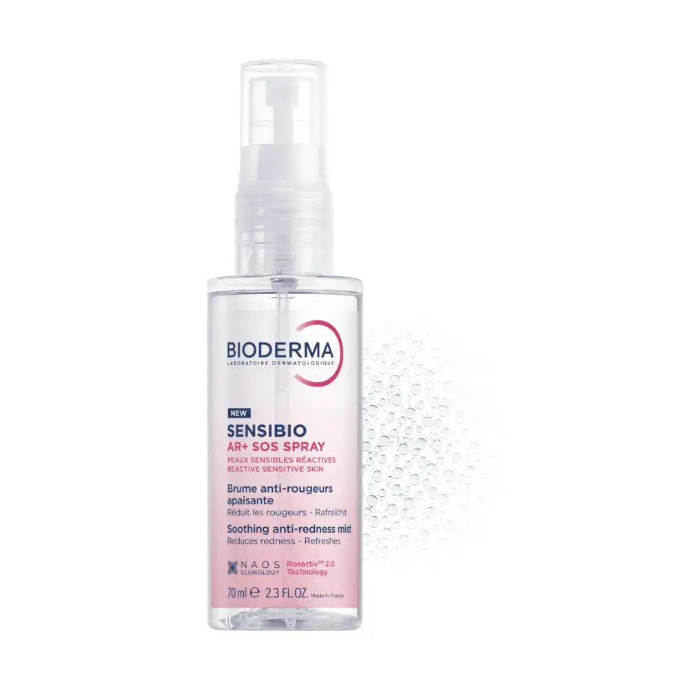 Bioderma Sensibio Anti-Redness Spray in a clear plastic bottle with a white spray pump, featuring a pink and blue label, set against a white background with a subtle water droplet pattern.