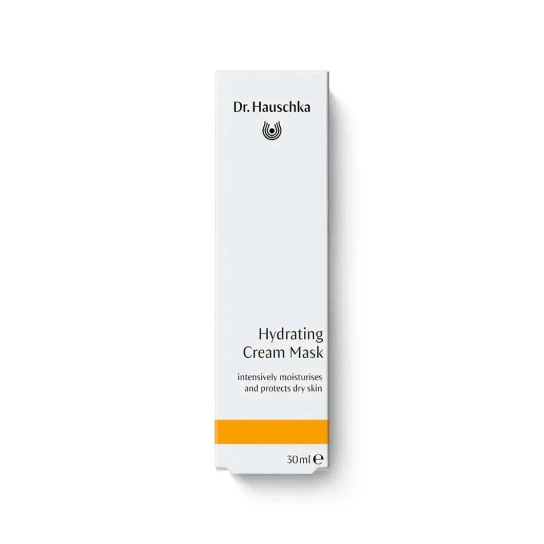 A tall, narrow white box for Dr. Hauschka Hydrating Cream Mask, featuring black text and a bright orange stripe near the bottom, set against a plain white background with a soft shadow.