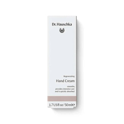 A tall, narrow white box for Dr. Hauschka Regenerating Hand Cream, featuring black text and a small black logo, with a light taupe band near the bottom, set against a clean white background.