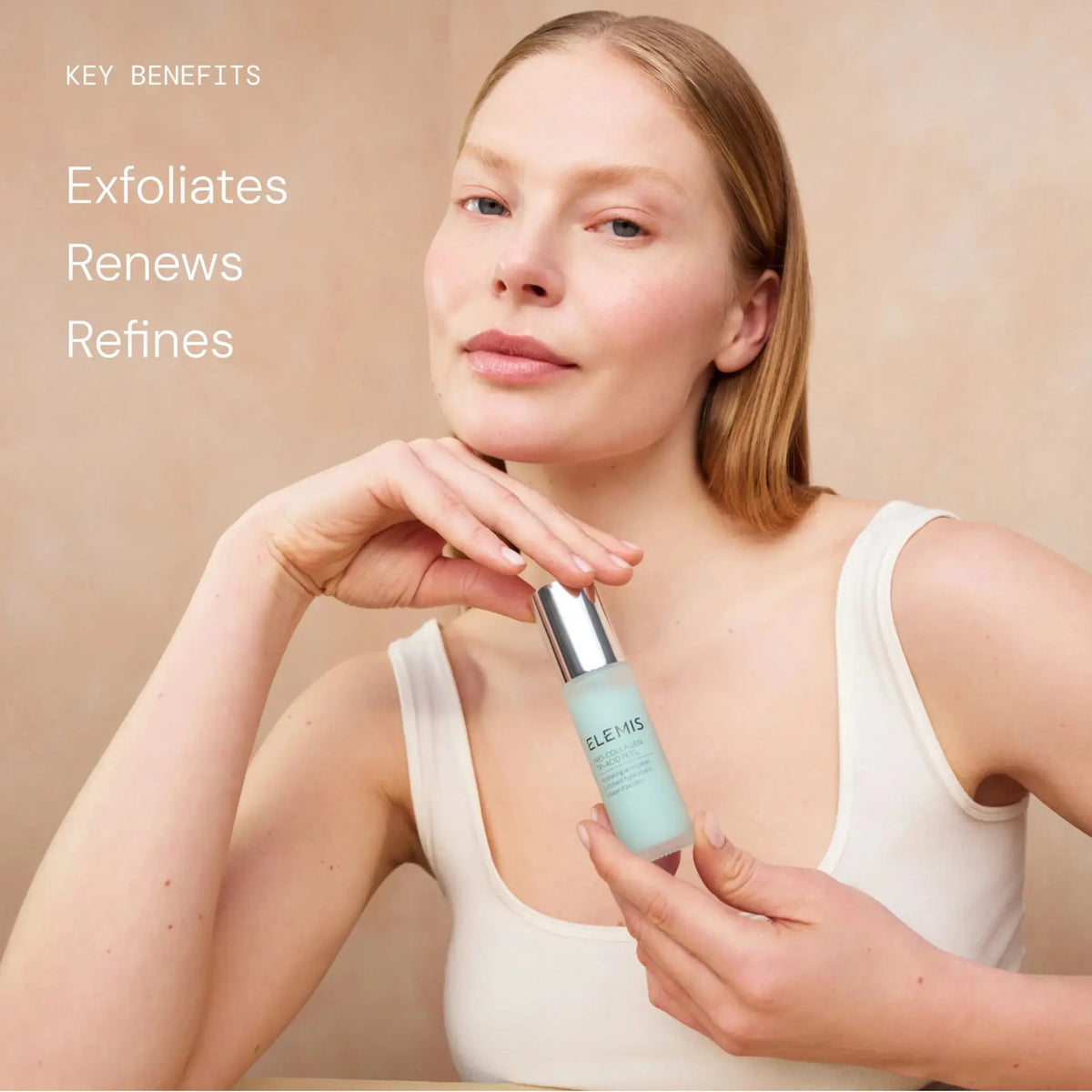 A woman in a white tank top holds a light blue skincare bottle with a silver pump against a warm beige background. White text on the left reads 'KEY BENEFITS Exfoliates Renews Refines'.