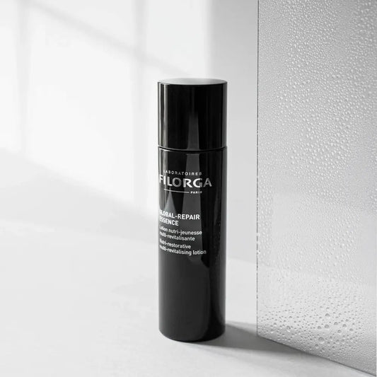 Black skincare bottle with visible branding on a light background