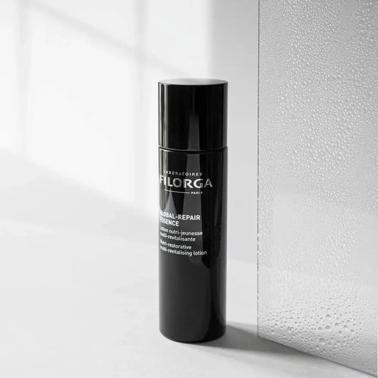 Black skincare bottle with visible branding on a light background