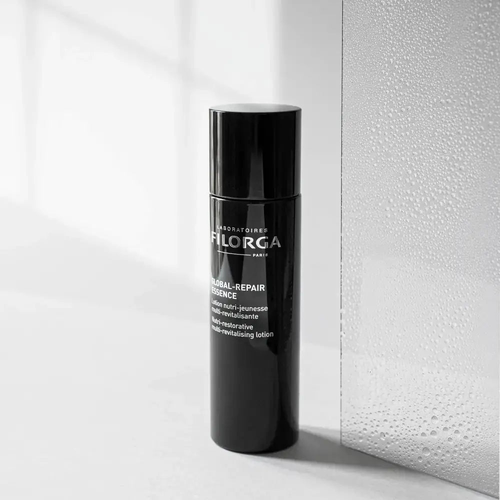 Black skincare bottle with visible branding on a light background