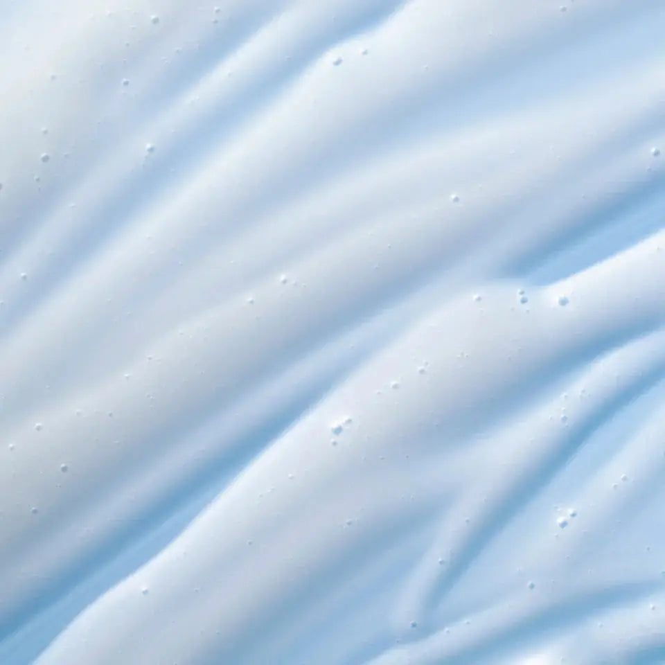 A close-up of a light blue and white textured surface with soft diagonal ridges and small dotted highlights.