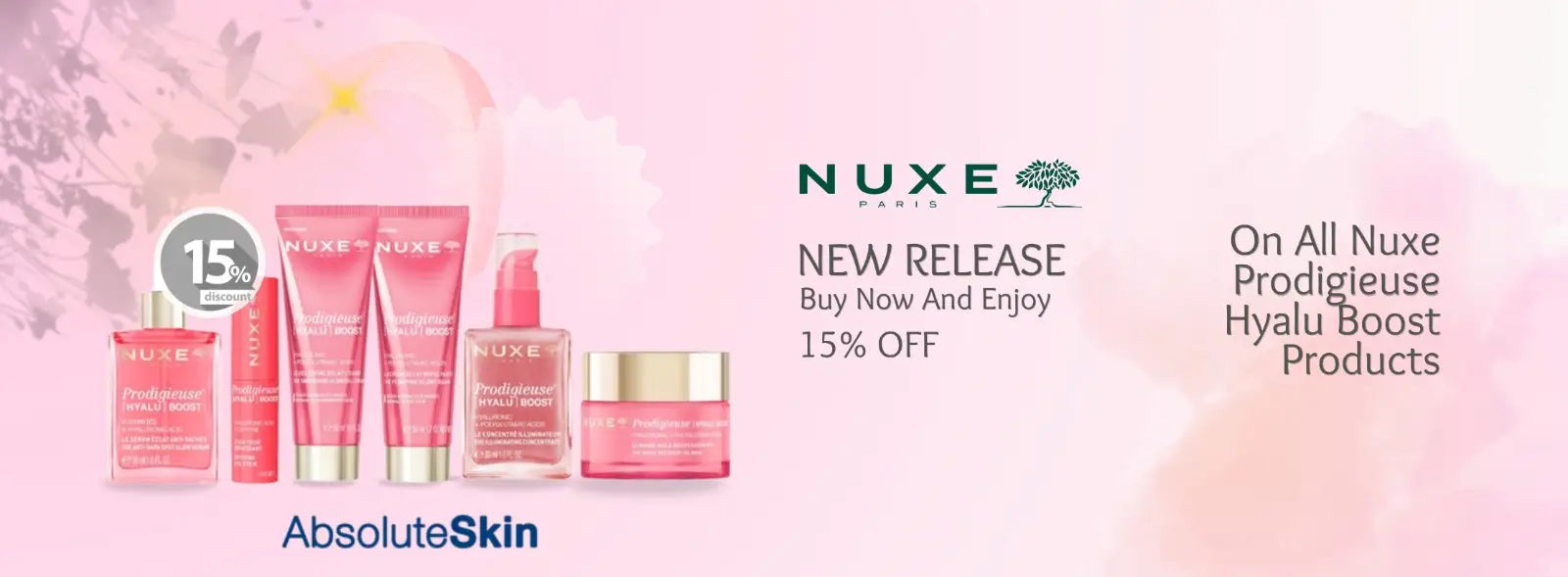 Nuxe Paris AbsoluteSkin skincare line promotional banner featuring pink and gold cosmetic bottles and jars on a soft pink background with promotional text.