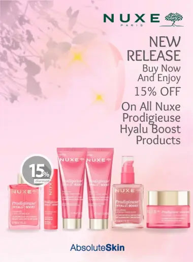 Nuxe Paris skincare promotional banner featuring several pink and red cosmetic tubes and jars with gold lids on a soft pink background, with text offering a 15% off purchase on Hyalu Boost products.