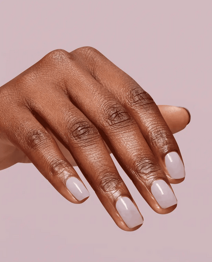 Hand with light beige nail polish on a pink background