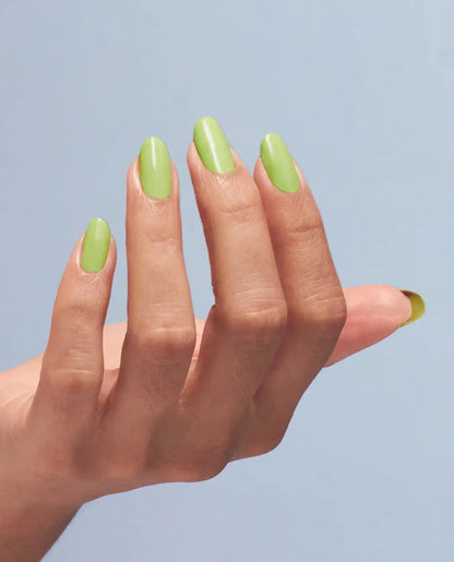 Hand with green nail polish on a light blue background