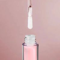 Load image into Gallery viewer, Close-up of a pink lip gloss with applicator on a light pink background
