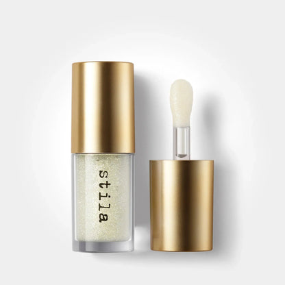 Stila cosmetic bottle with gold cap and applicator on a white background