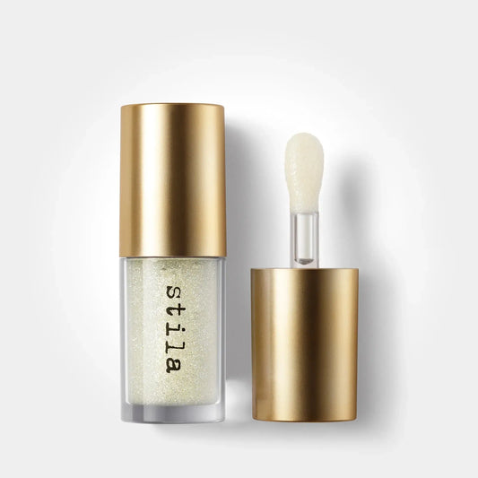 Stila cosmetic bottle with gold cap and applicator on a white background