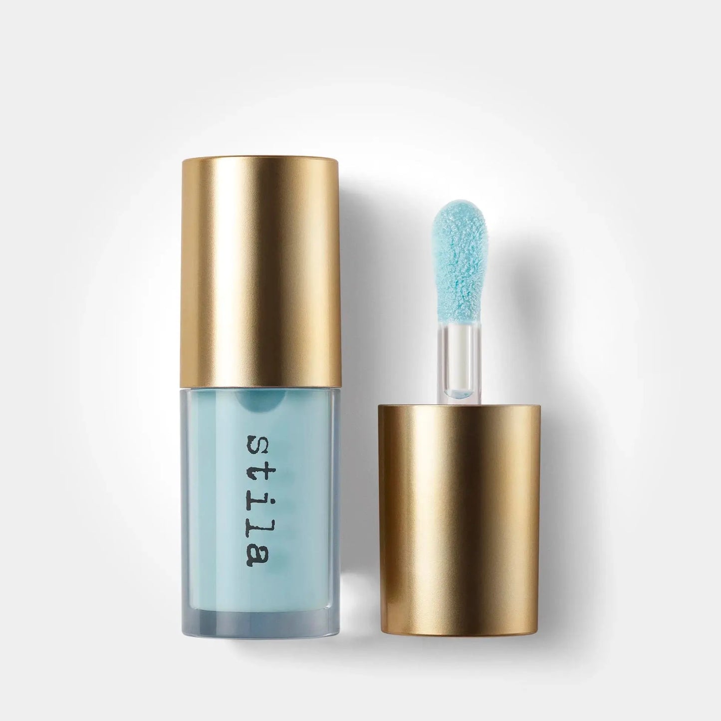 Stila cosmetic product with gold cap and blue applicator on a white background