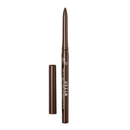 A brown makeup eye pencil with its cap removed, displayed vertically next to the cap on a plain white background. The brand name 'ST.