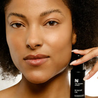 Load image into Gallery viewer, Woman holding a bottle of &#39;The Natural Africa&#39; Rosehip Oil with a neutral background
