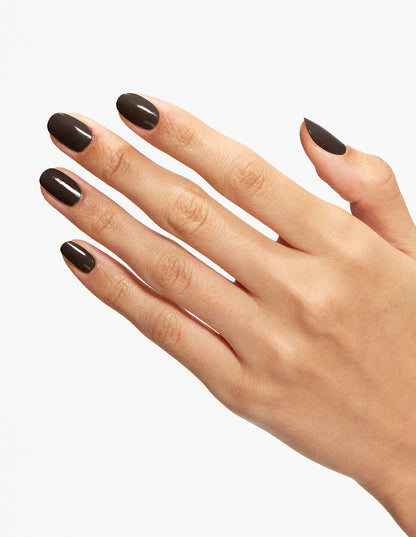 A close-up of a hand with glossy dark brown nail polish against a clean white background.